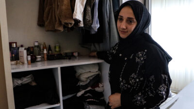 Adana’nın Yüreğir ilçesinde, okuldan gelecek çocukları için evin dışındaki ayakkabılığa