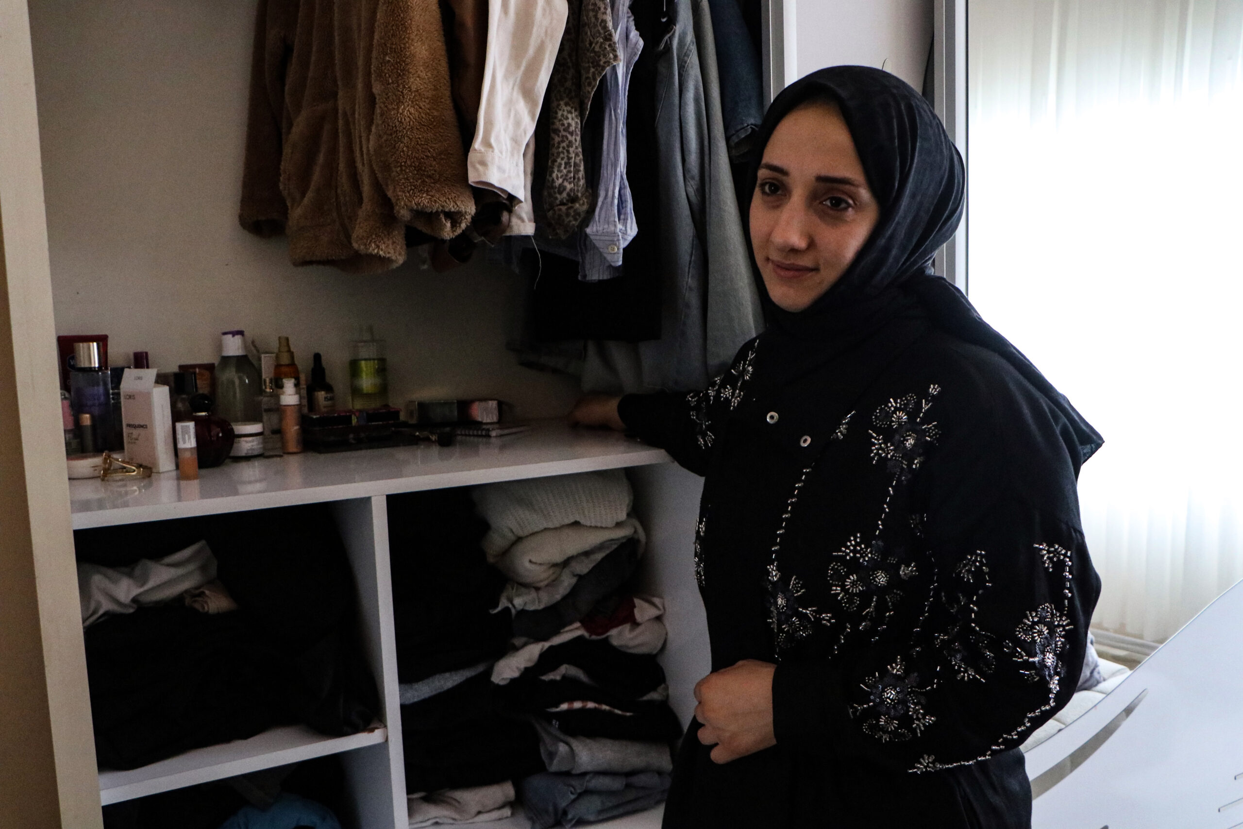 Adana’nın Yüreğir ilçesinde, okuldan gelecek çocukları için evin dışındaki ayakkabılığa